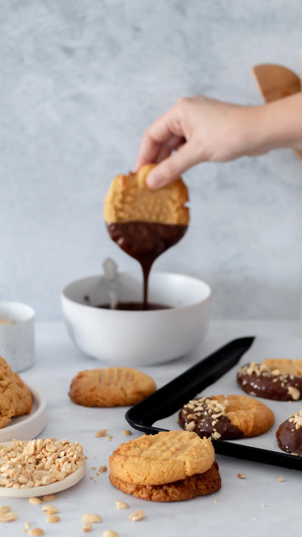 Mano sumergiendo una galletita en un bowl de chocolate derretido